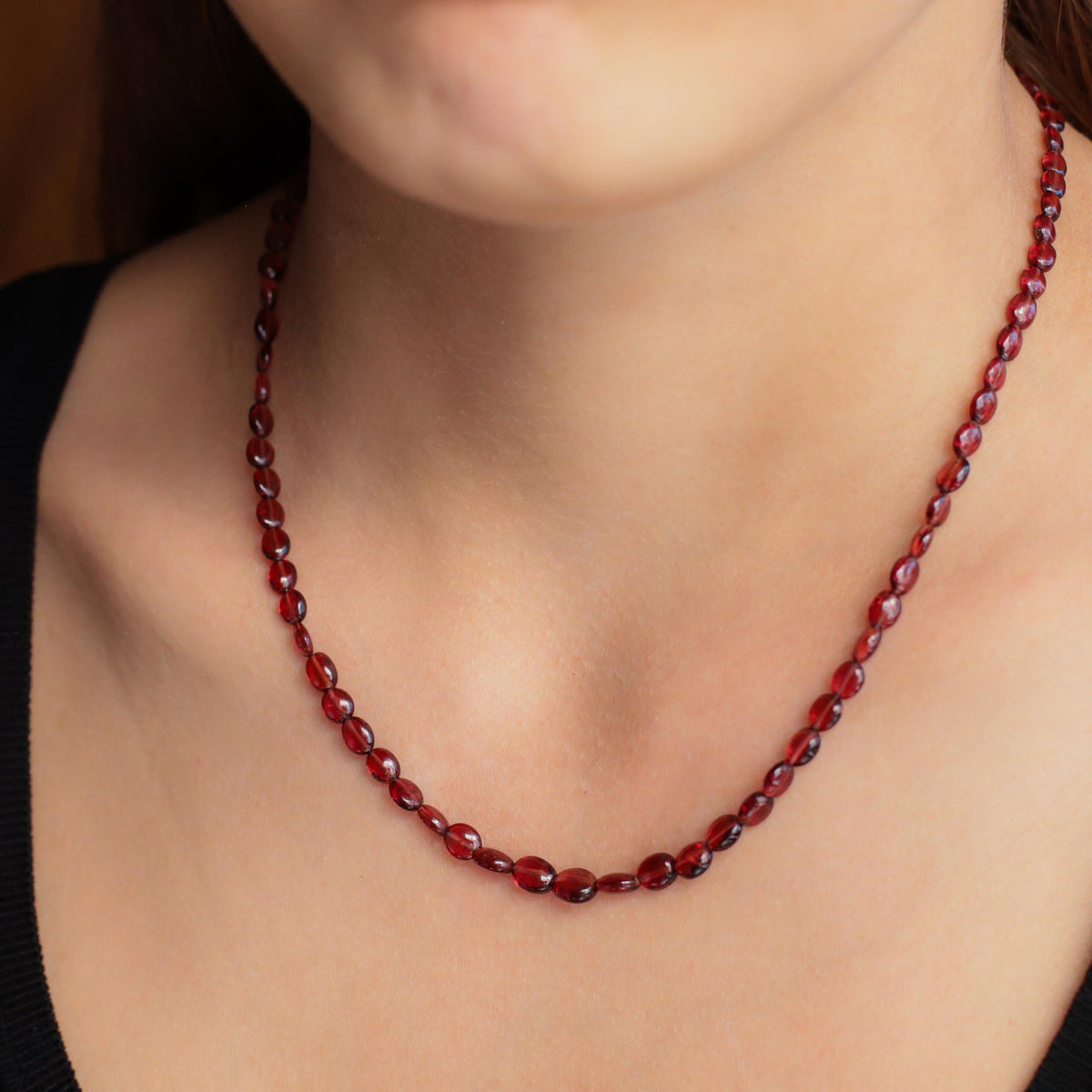 Garnet beaded oval necklace from Earthly Abundance featuring a string of polished red garnet beads and a silver clasp.
