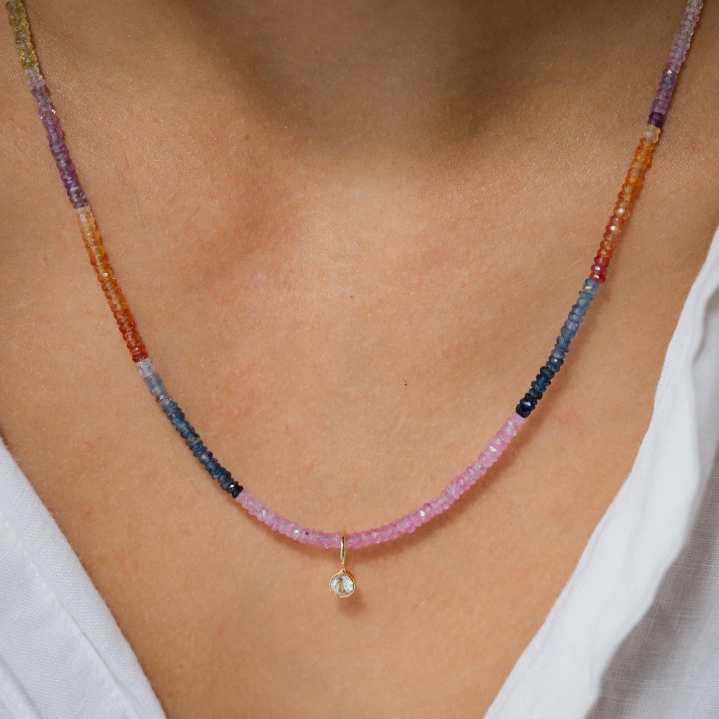 Multi sapphire necklace by Earthly Abundance featuring a delicate chain with vibrant blue and purple sapphires arranged in a elegant design.