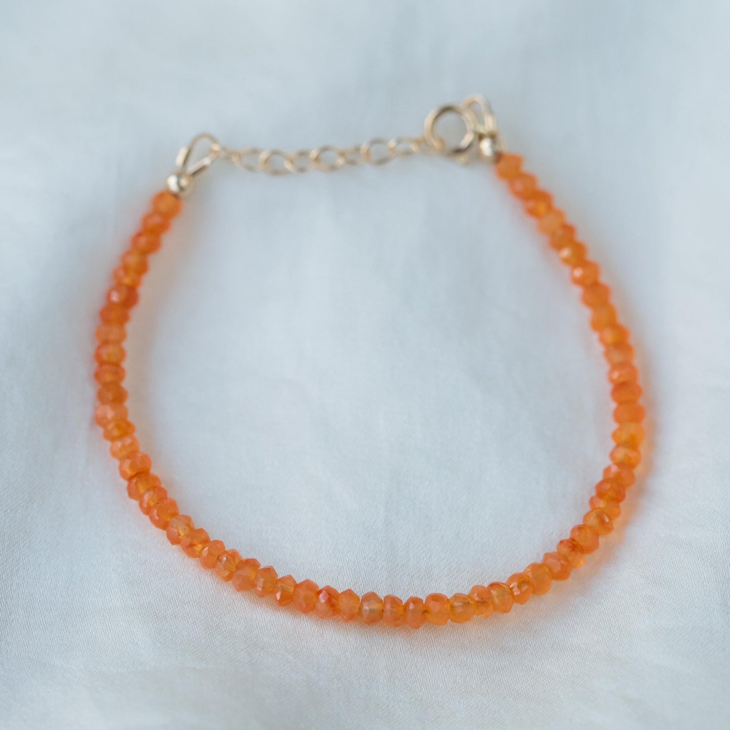 Carnelian bracelet with 14K gold accents from Earthly Abundance, featuring polished orange stones on a delicate chain.