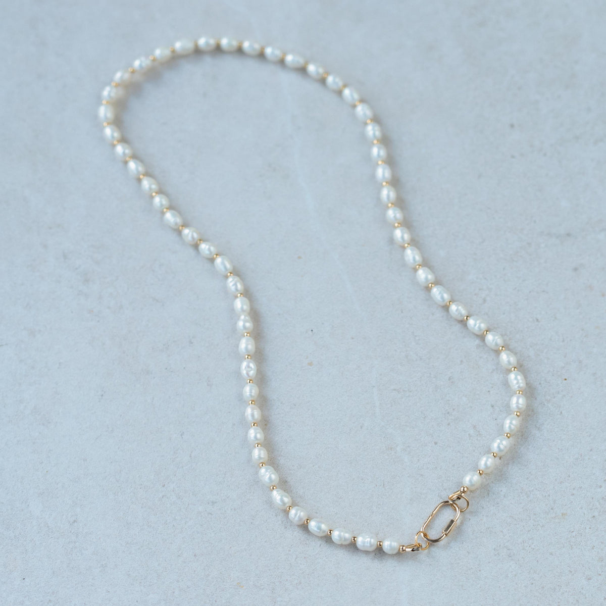 Freshwater pearl necklace with 14K gold clasp from Earthly Abundance, featuring lustrous white pearls on a delicate chain.