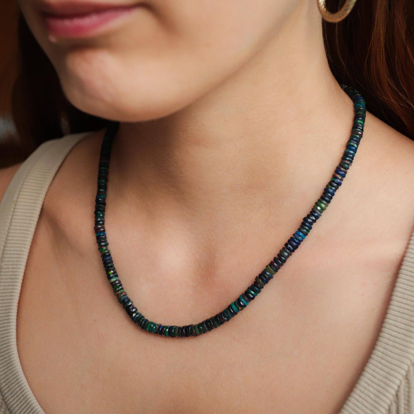 Black Ethiopian Opal beaded necklace with dark, iridescent stones from Earthly Abundance displayed on a neutral background.
