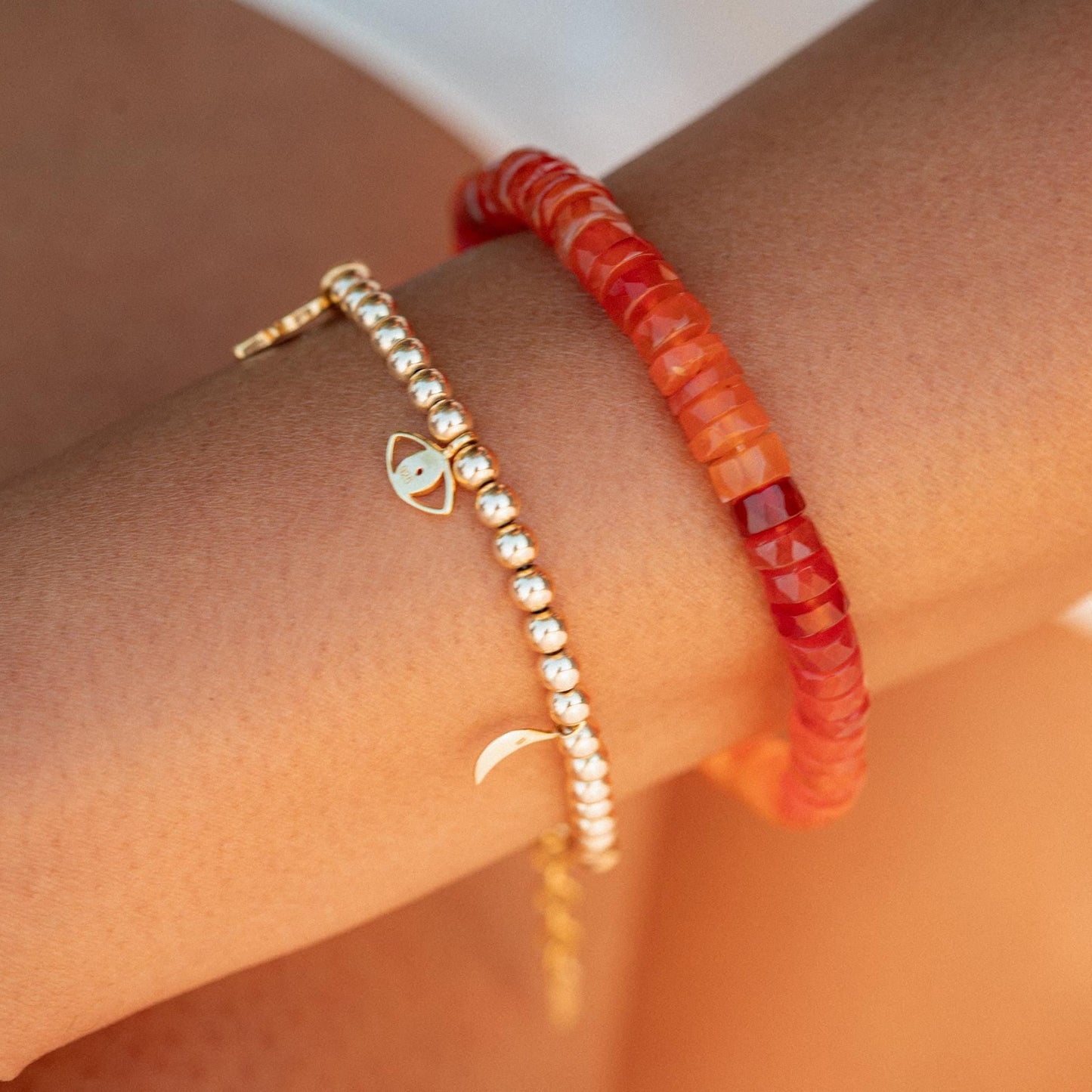 Earthly Abundance Carnelian heishi bracelet with orange beads and natural stone design on an elastic band.