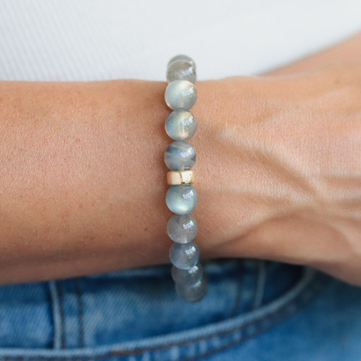 Labradorite bracelet with 9mm beads featuring a 14K gold clasp, showcasing iridescent labradorite stones on a neutral background.