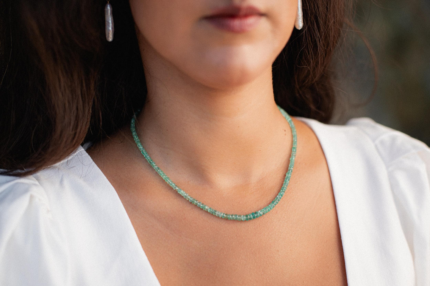 Zambian emerald necklace with 14K gold chain featuring a vibrant green emerald pendant. Natural, elegant jewelry piece.