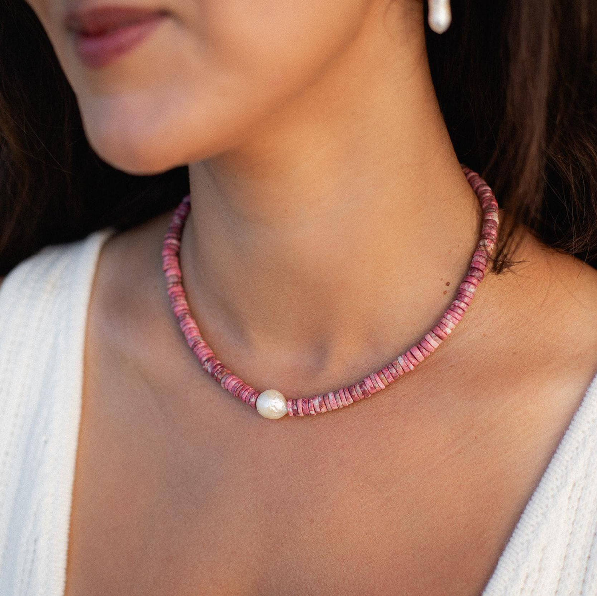 Pink Thulite pearl necklace by Earthly Abundance Jewelry featuring pink pearls and elegant design on a black background.