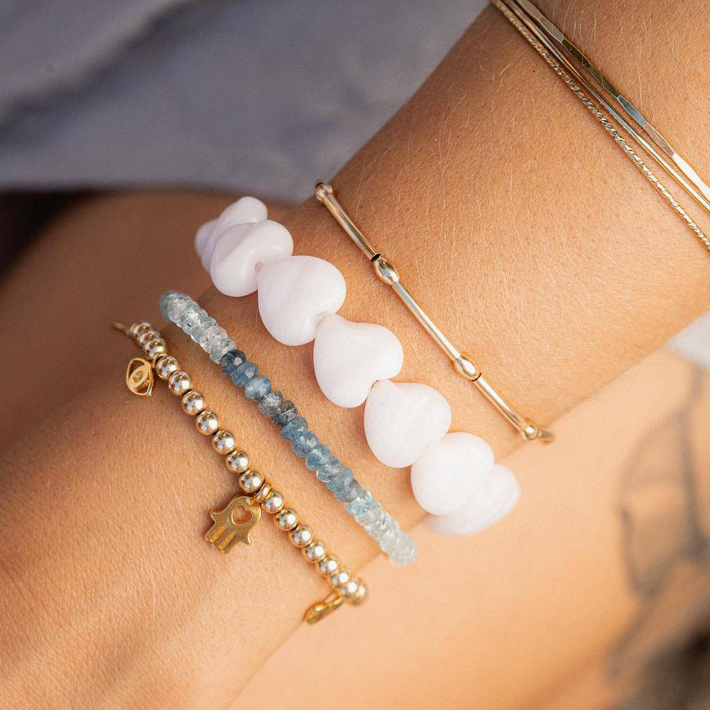 Pink mango calcite heart-shaped bracelet from Earthly Abundance Jewelry featuring polished stones and adjustable string.