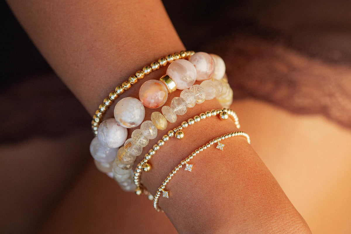 Golden rutilated quartz bracelet featuring polished beads with golden needle-like inclusions, crafted by Earthly Abundance.