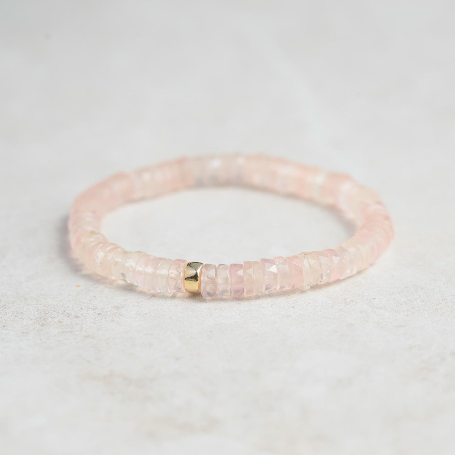 Rose Quartz Heishi bracelet by Earthly Abundance featuring smooth pink gemstone beads strung on an elastic band.