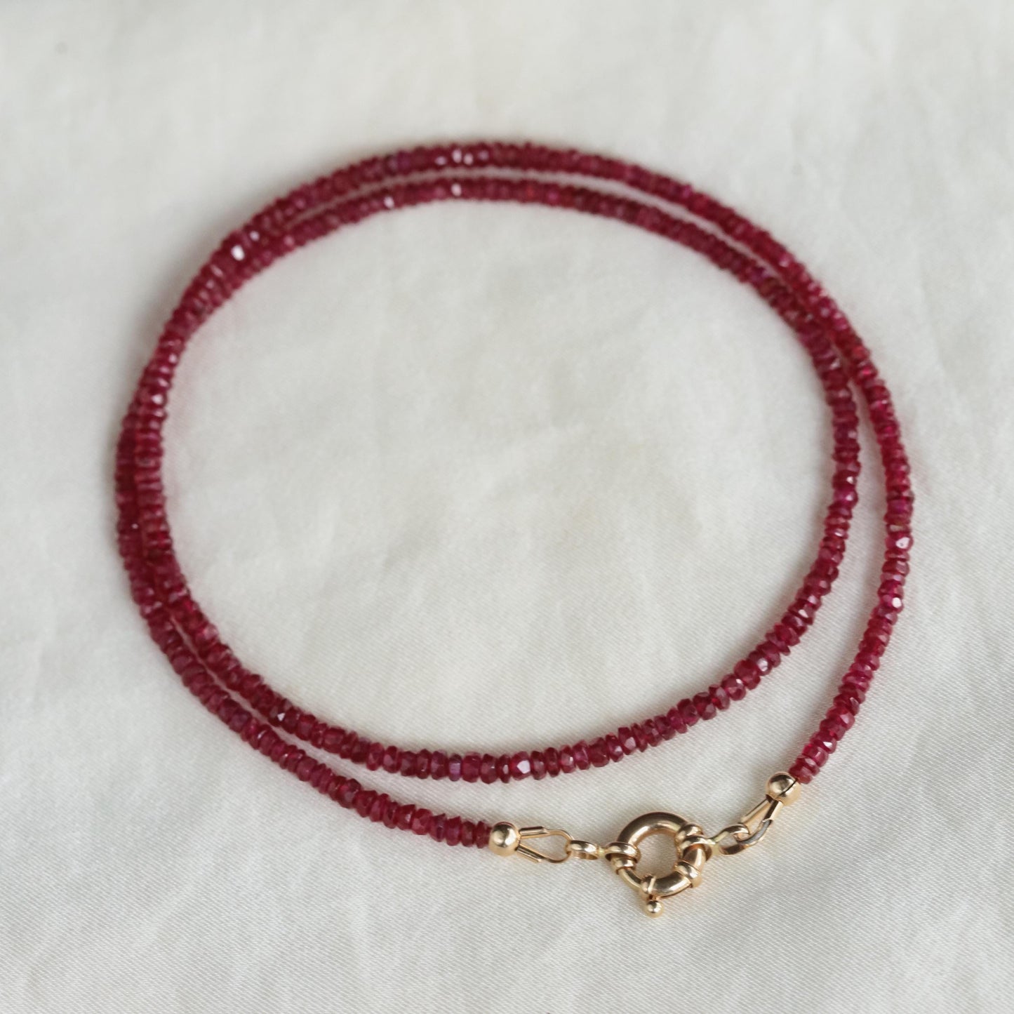14K Anchor Ruby Necklace by Earthly Abundance featuring a polished silver anchor pendant with a vibrant ruby gemstone.