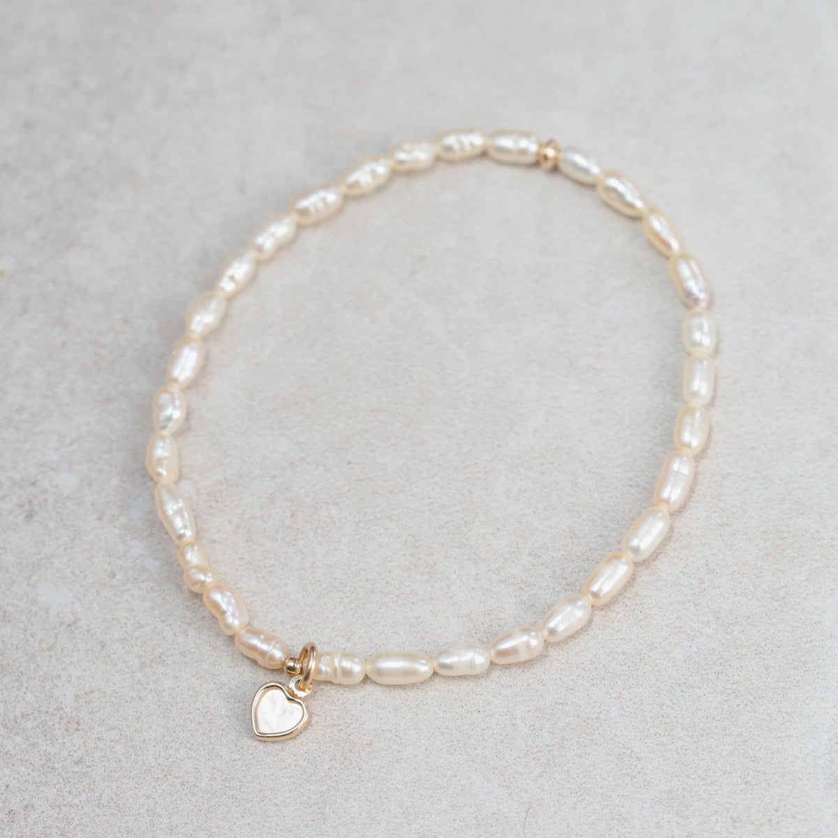 Freshwater pearl bracelet by Earthly Abundance featuring lustrous white pearls on a delicate clasp.