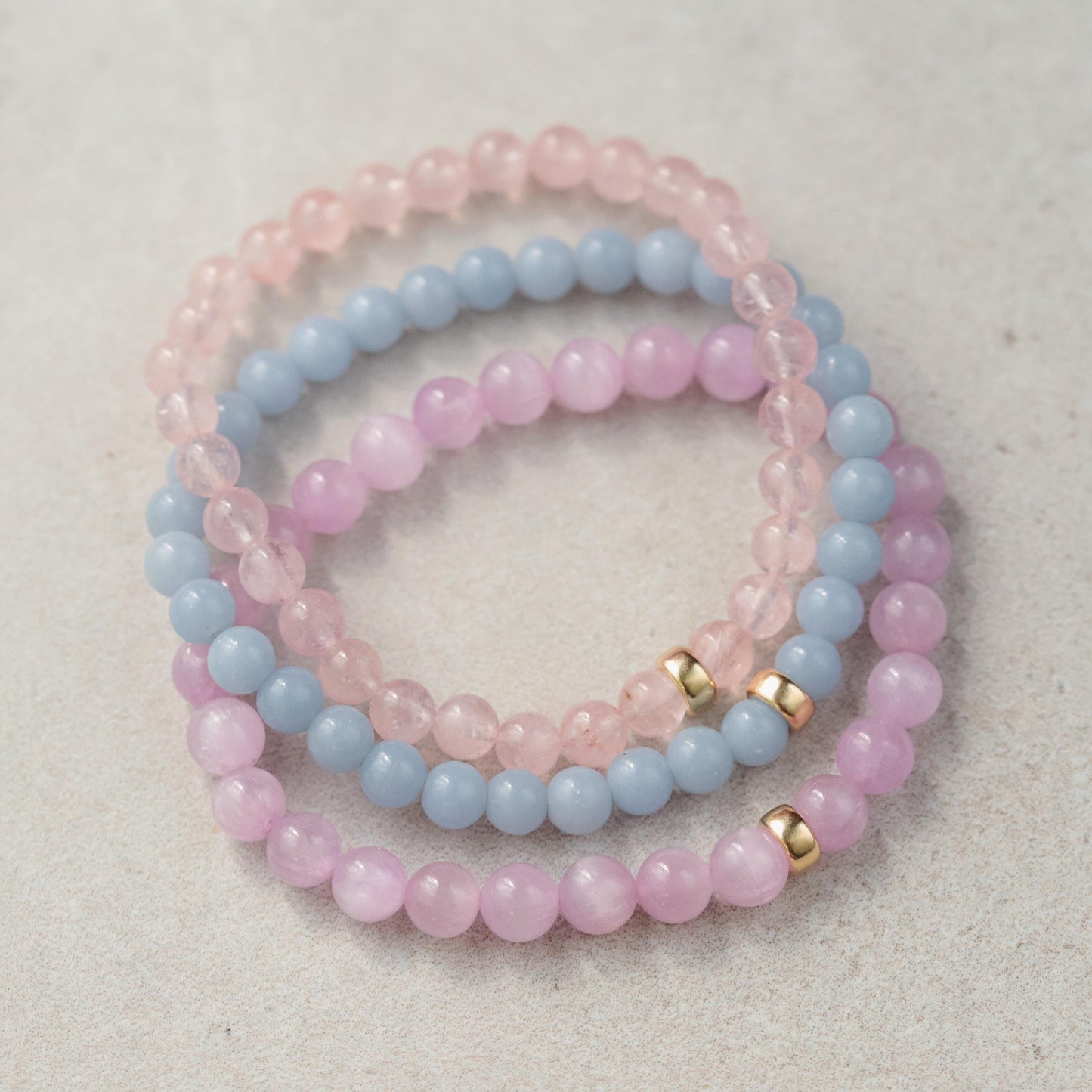 Kunzite bracelet with 7mm beads from Earthly Abundance, featuring pinkish-purple gemstones on a delicate elastic band.