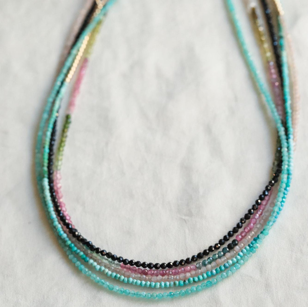 Mixed tourmaline necklace with 2mm beads from Earthly Abundance Jewelry, showcasing colorful semi-precious gemstone strands.