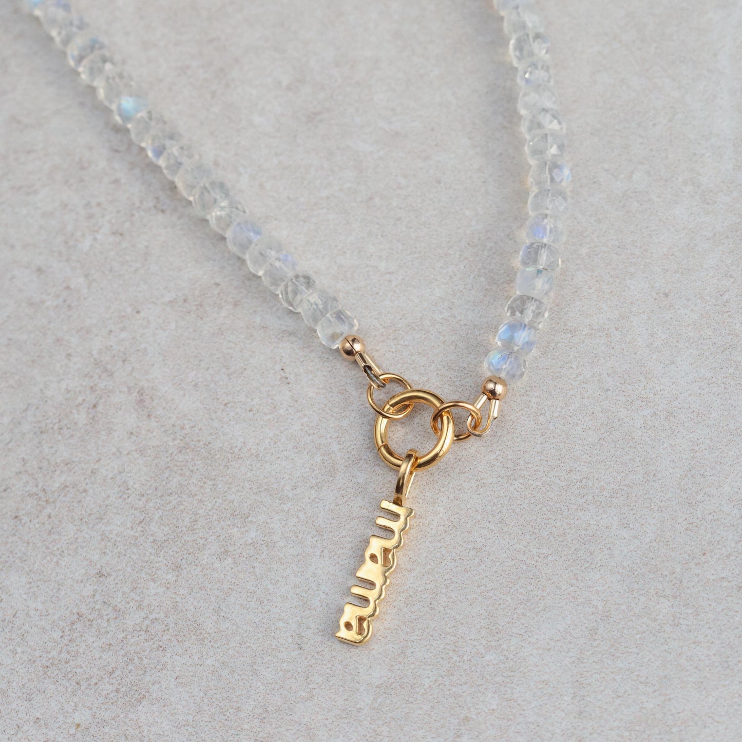 Rainbow Moonstone carabiner necklace from Earthly Abundance featuring a polished moonstone pendant on a metal chain.