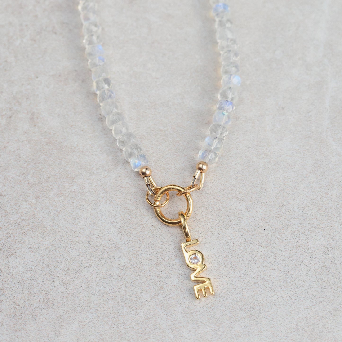 Rainbow Moonstone carabiner necklace by Earthly Abundance, featuring a polished moonstone pendant on a sturdy metal carabiner clip.
