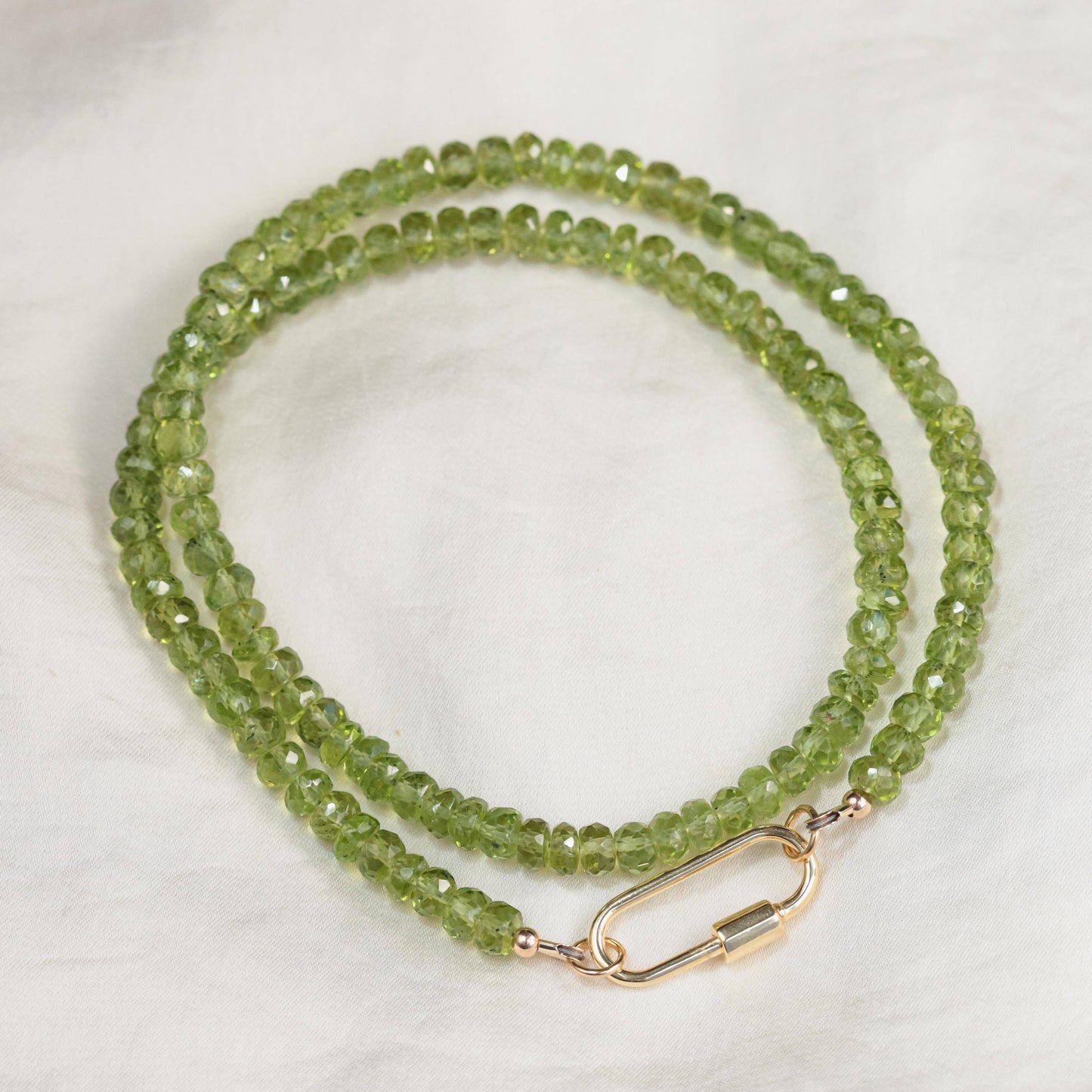 Peridot gemstone carabiner necklace by Earthly Abundance featuring a green peridot stone on a silver chain.