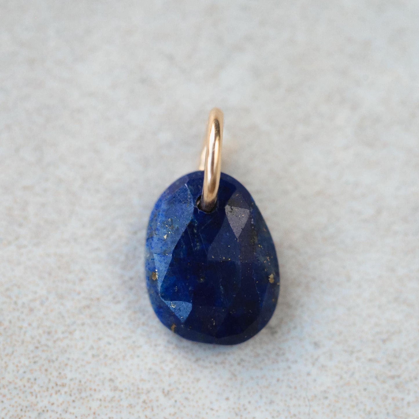 Lapis Lazuli pendant necklace with 14K gold setting, featuring a deep blue gemstone, on a delicate gold chain.