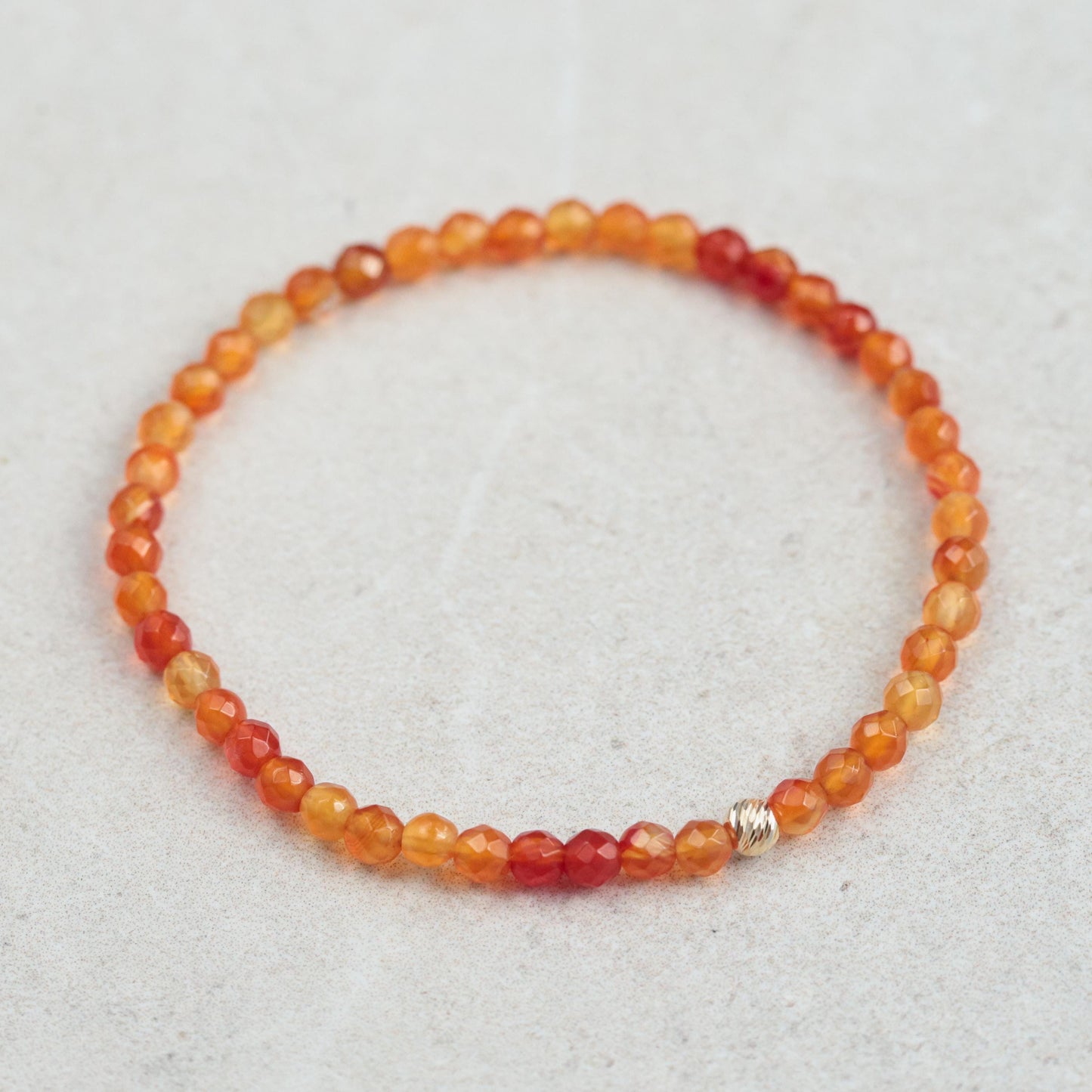 Mini Carnelian pendant in 14K gold with a polished orange gemstone, featuring a delicate gold setting and chain.