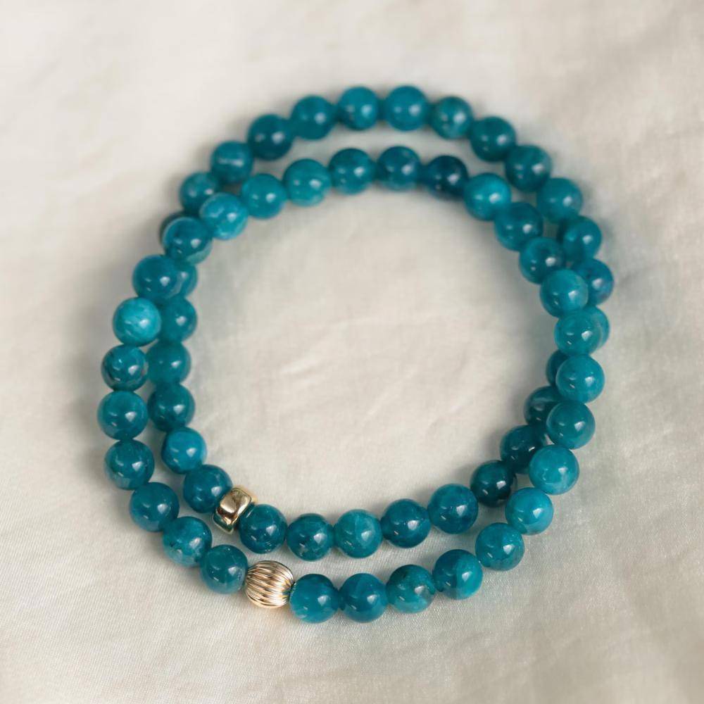 Neon blue Apatite gemstone bead, 6mm, from Earthly Abundance Jewelry, displaying a vibrant, polished mineral with a smooth round shape.