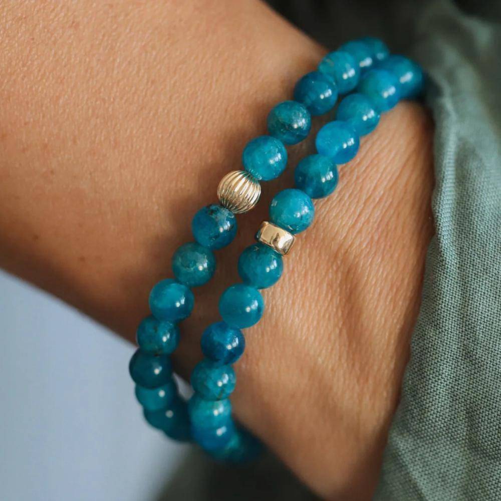 Neon blue apatite gemstone beads, 6mm size, from Earthly Abundance Jewelry, showing glossy, vibrant blue mineral spheres.