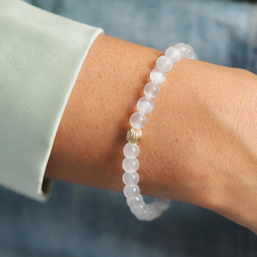 Selenite bracelet from Earthly Abundance Jewelry featuring smooth, white selenite stones on an elastic band.