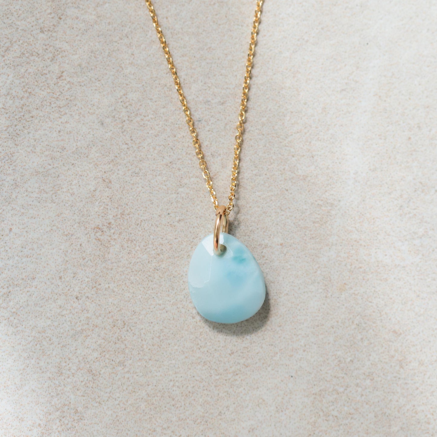 Larimar pendant necklace from Earthly Abundance featuring a smooth, oval-shaped blue larimar gemstone on a silver chain.