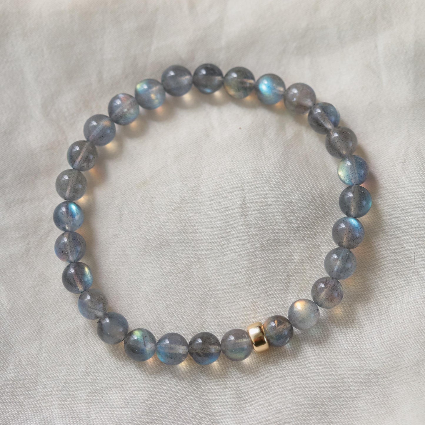 Spiritual Insight Labradorite gemstone from Earthly Abundance, showcasing its iridescent flash and natural gray stone appearance.