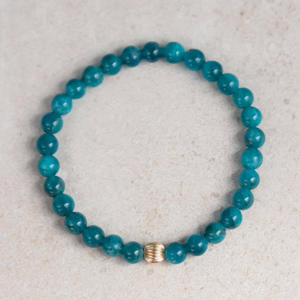 Neon blue apatite 6mm gemstone bead from Earthly Abundance Jewelry, showcasing its vibrant color and smooth round shape.
