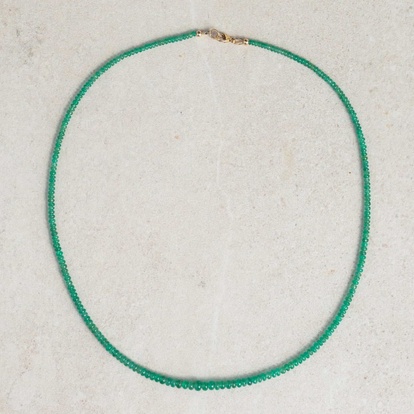 Zambian emerald smooth rondel necklace featuring vibrant green emerald beads on a delicate chain, crafted by Earthly Abundance.