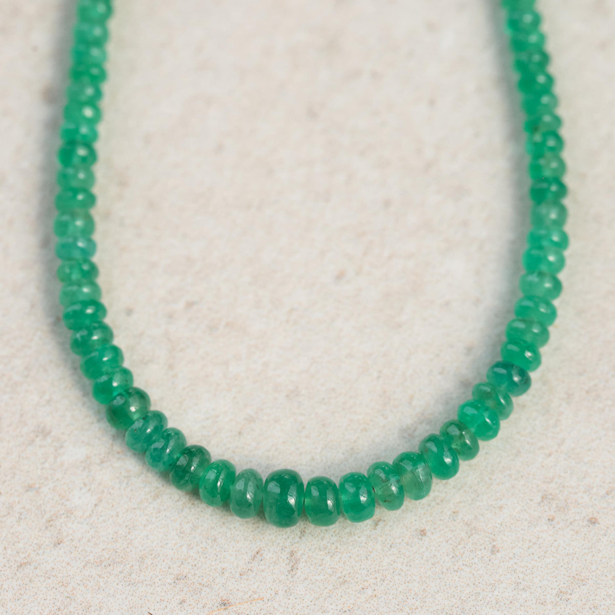 Zambian emerald smooth rondel necklace with green gemstones on a delicate chain, showcasing elegant jewelry design.