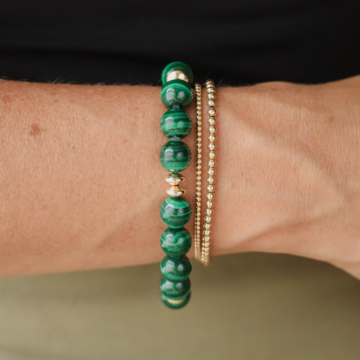Earthly Abundance 10mm malachite bracelet featuring polished green gemstone beads on an elastic band.