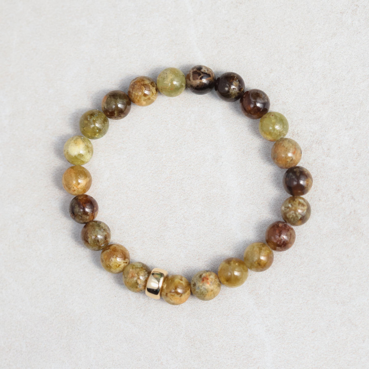 Green garnet bracelet with 14K gold setting featuring polished round garnet stones, elegant jewelry accessory.