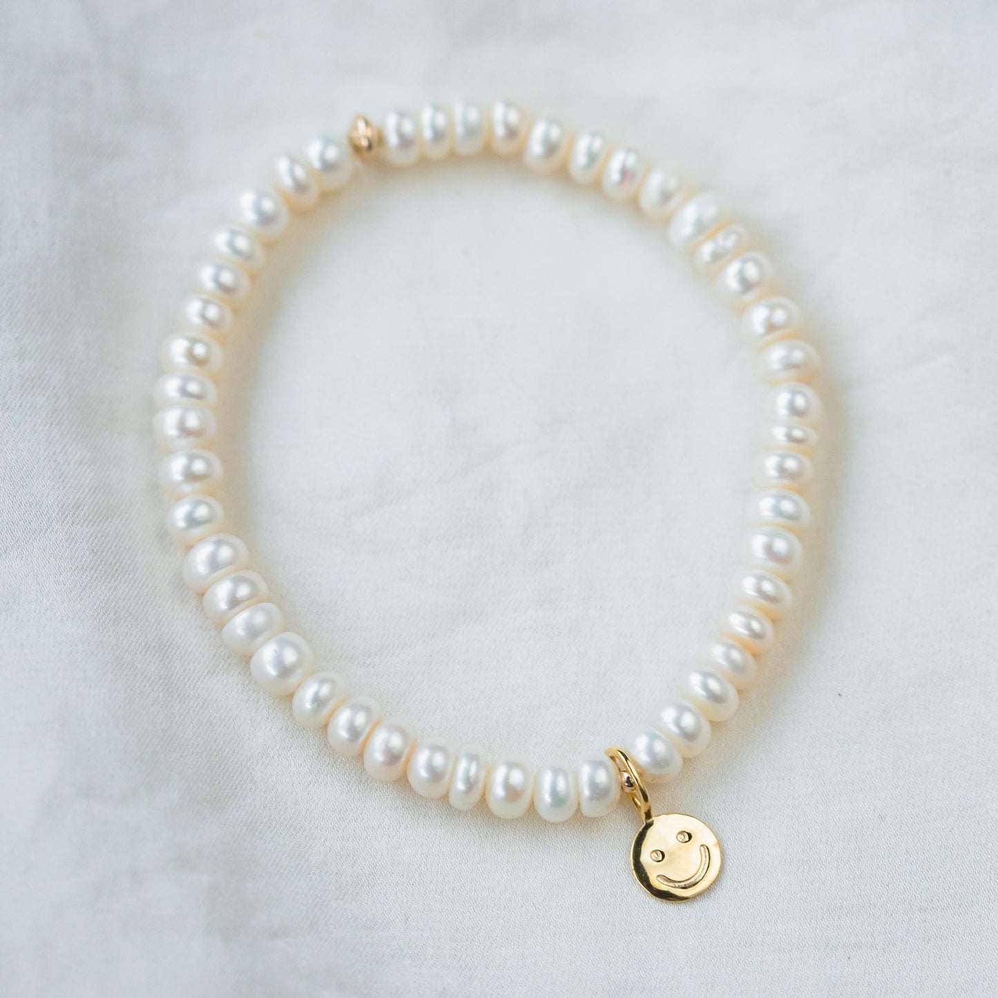 Elegant freshwater pearl bracelet by Earthly Abundance featuring lustrous white pearls on a delicate chain.