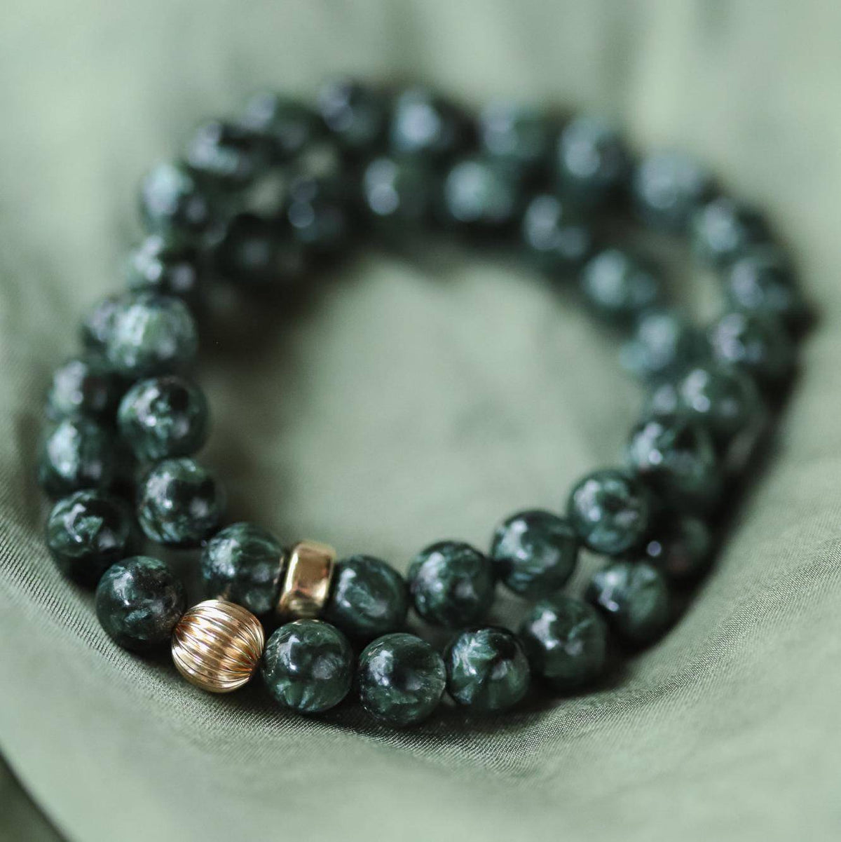 Seraphinite 8mm gemstone beads from Earthly Abundance Jewelry, showcasing deep green and silvery chatoyancy.