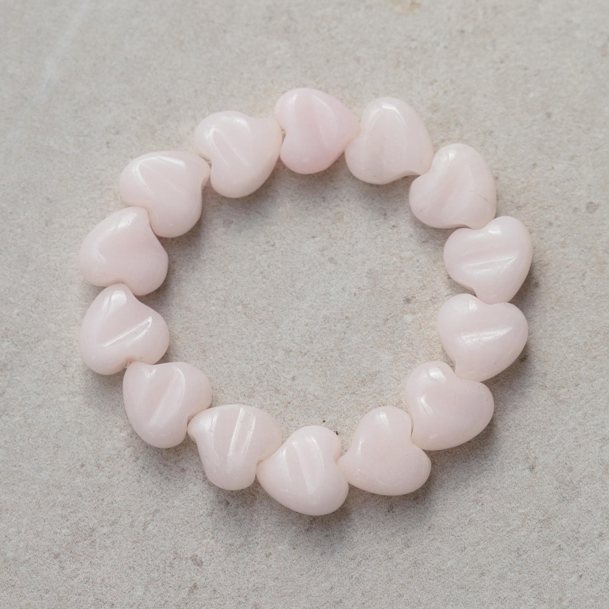 Heart-shaped pink mango calcite bracelet from Earthly Abundance Jewelry featuring polished pink calcite stones on an elastic band.
