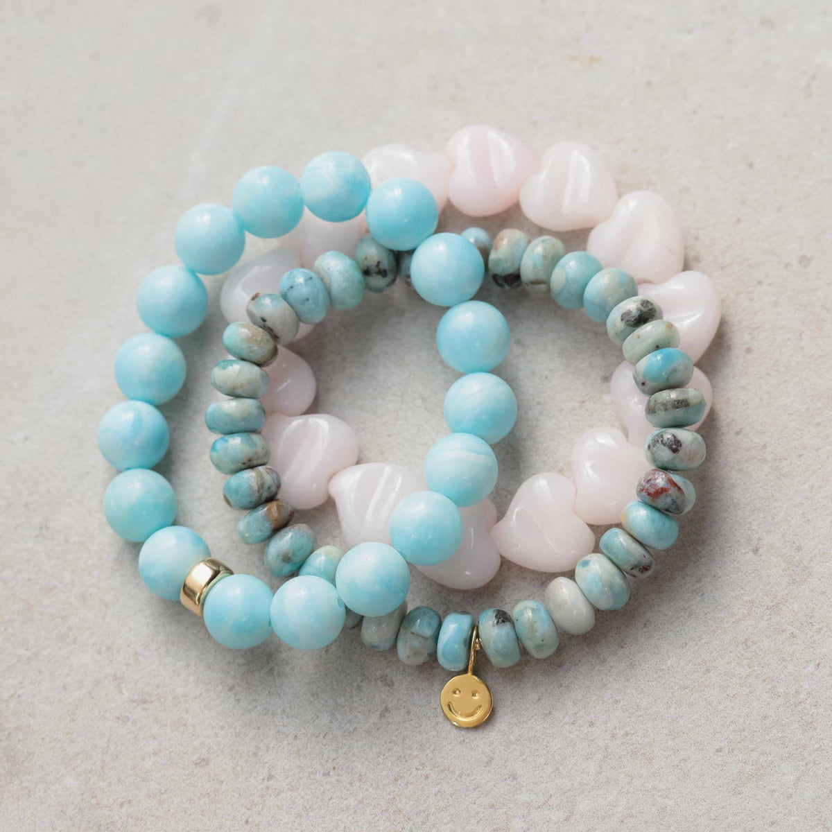 Pink mango calcite bracelet with heart-shaped beads from Earthly Abundance Jewelry displayed on a neutral background.