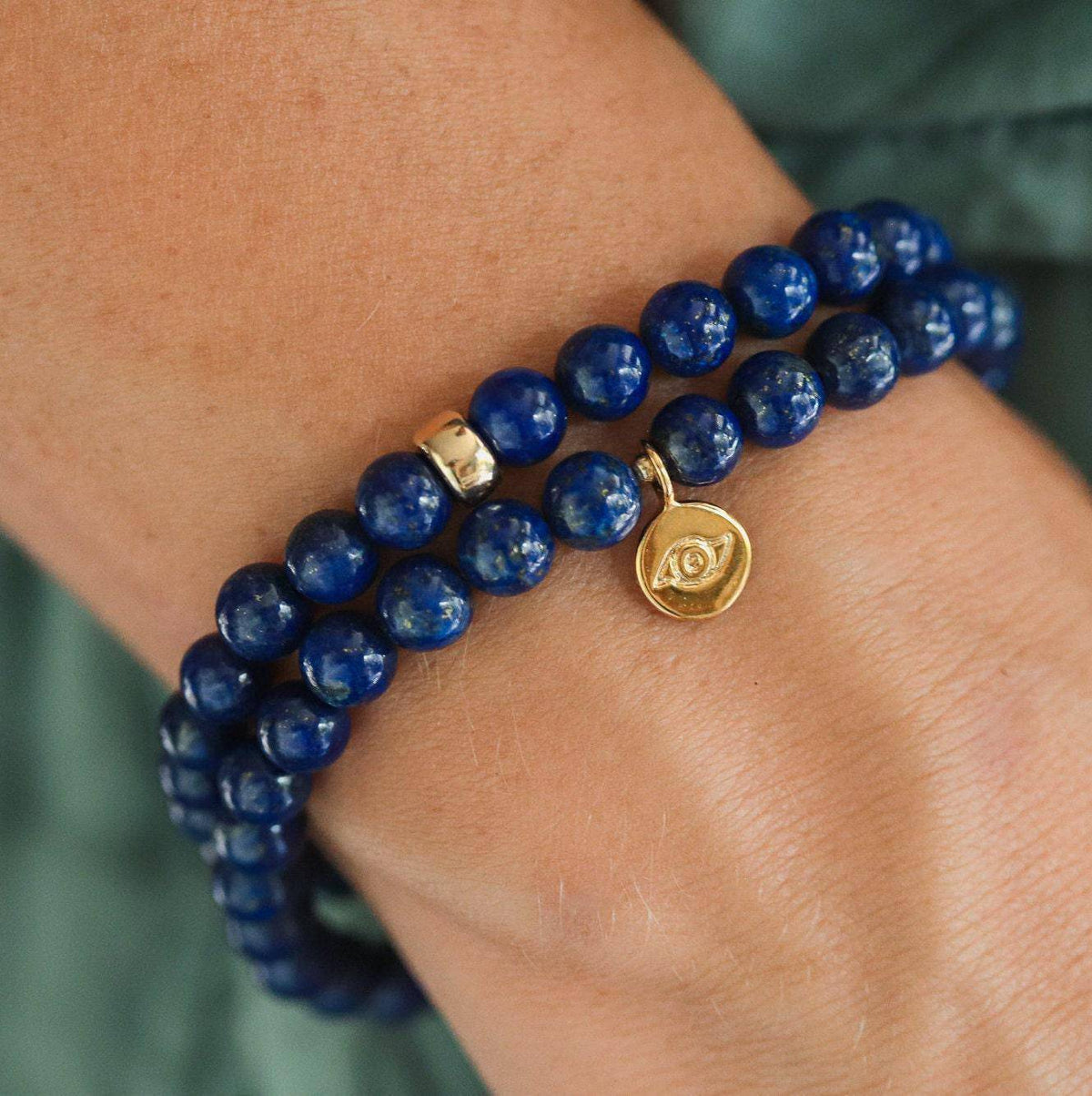 Lapis Lazuli bracelet with deep blue stones and gold accents from Earthly Abundance Jewelry, displayed on a white background.