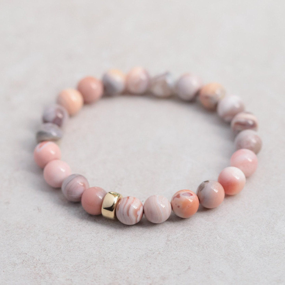 Pink Botswana Agate bracelet by Earthly Abundance featuring smooth, polished pink agate beads on an elastic band.