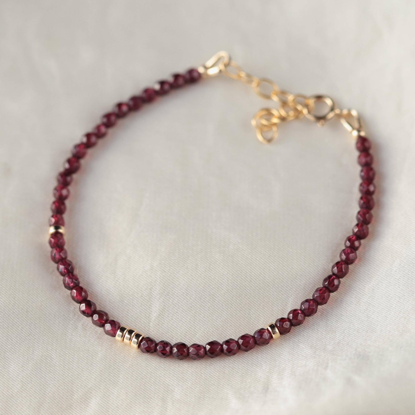 Garnet beaded bracelet by Earthly Abundance Jewelry featuring polished red garnet stones on an elastic band.