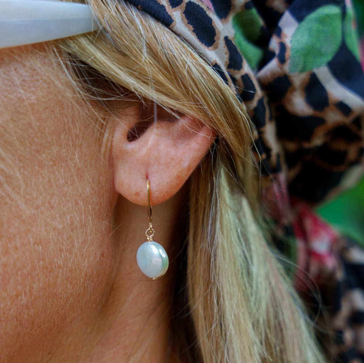Freshwater disc pearl earrings in 14K gold from Earthly Abundance, featuring round white pearls with gold stud posts.