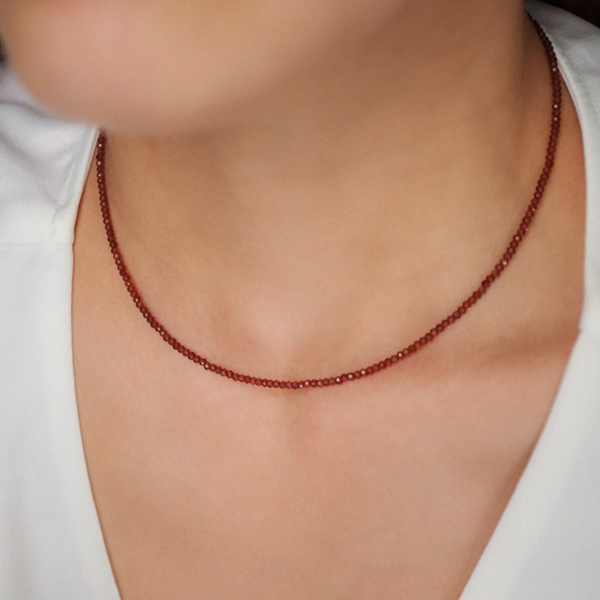 Earthly Abundance garnet 2mm necklace featuring small red gemstone beads on a delicate chain.