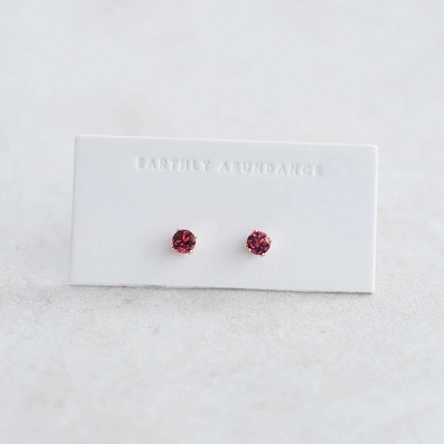 Pink tourmaline stud earring by Earthly Abundance featuring a sparkling pink gemstone set in a silver or gold stud.