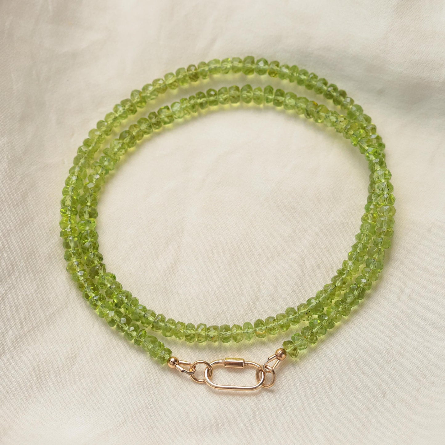 Peridot pearl carabiner necklace featuring green peridot stones and white pearls on a silver chain from Earthly Abundance.