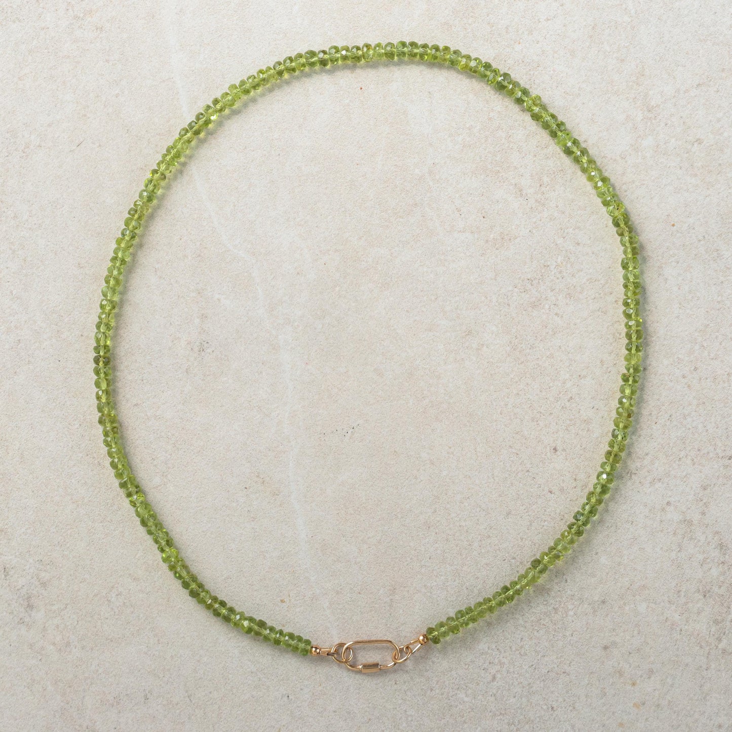 Peridot and pearl carabiner necklace by Earthly Abundance featuring green peridot stones and elegant pearls on a silver chain.