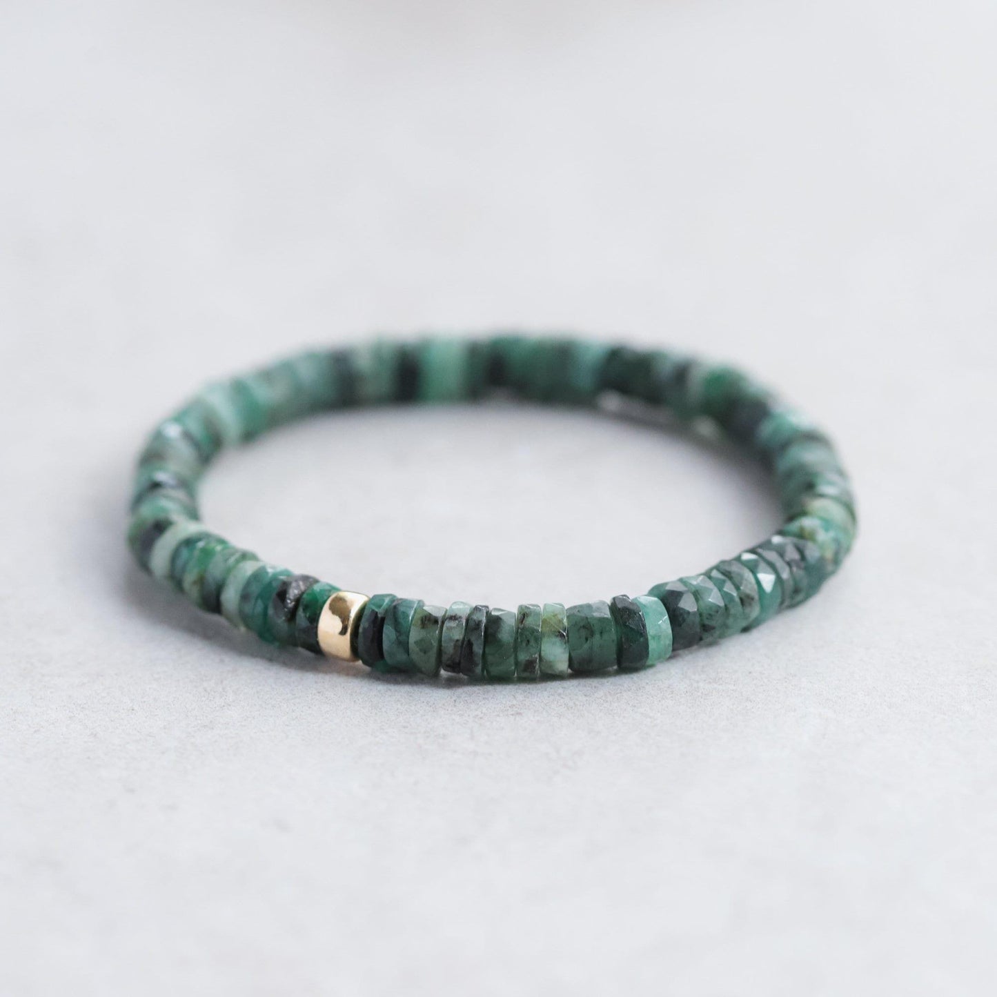 Emerald Heishi bracelet by Earthly Abundance featuring small green gemstone beads on a stretch cord.