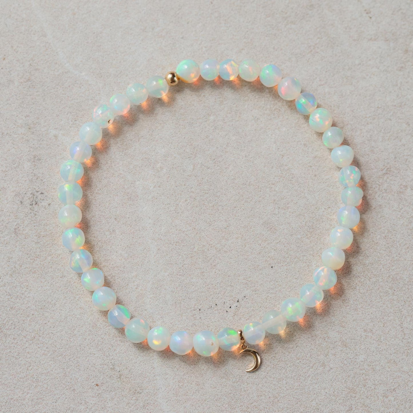 Ethiopian opal moon bracelet with 14K gold, featuring luminous opal moon charms on a delicate gold chain.