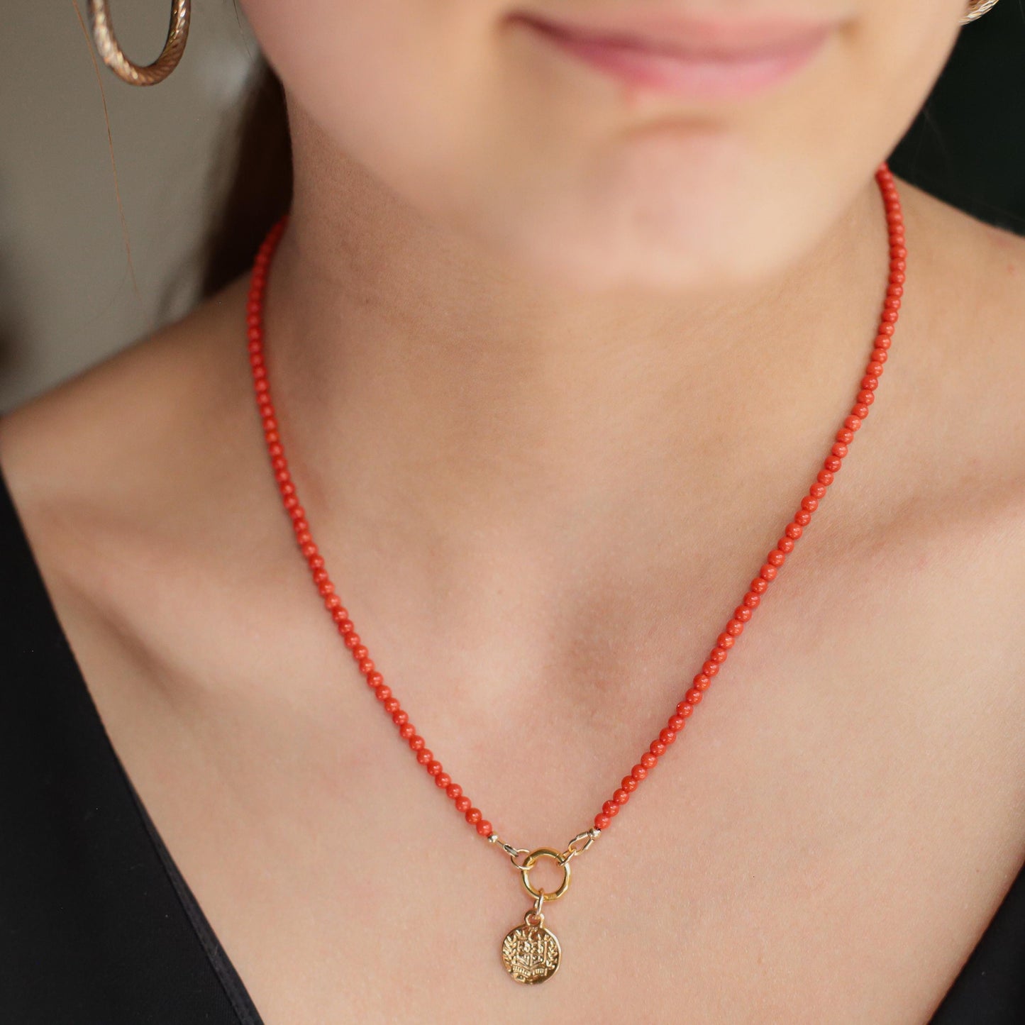 Earthly Abundance Italian Coral Greek necklace featuring vibrant red coral beads and gold accents on a delicate chain.