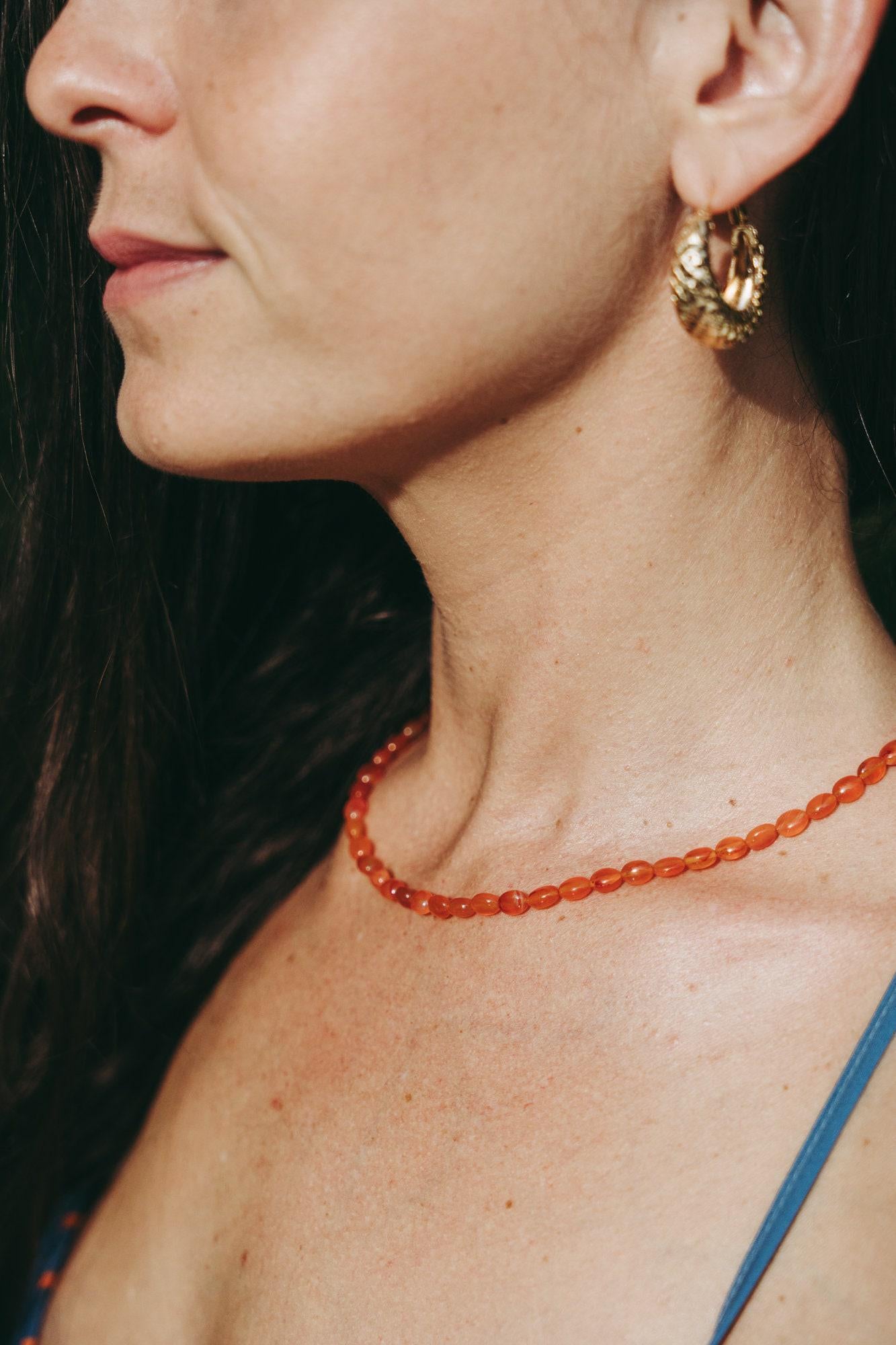 Earthly Abundance Jewelry Carnelian beaded oval necklace with orange-red stones on a delicate chain.