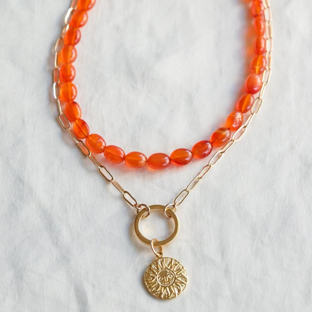 Carnelian beaded oval necklace with earth-toned beads from Earthly Abundance Jewelry, displayed on a neutral background.