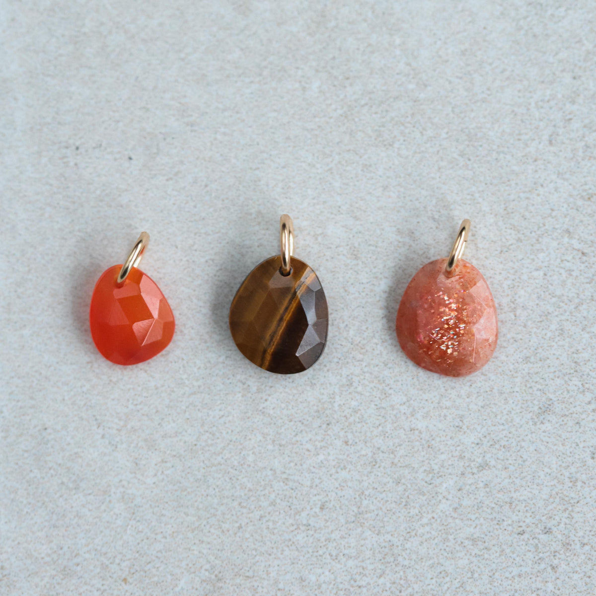 Sunstone pendant necklace in 14K gold with a polished sunstone gemstone, featuring a delicate chain on a neutral background.