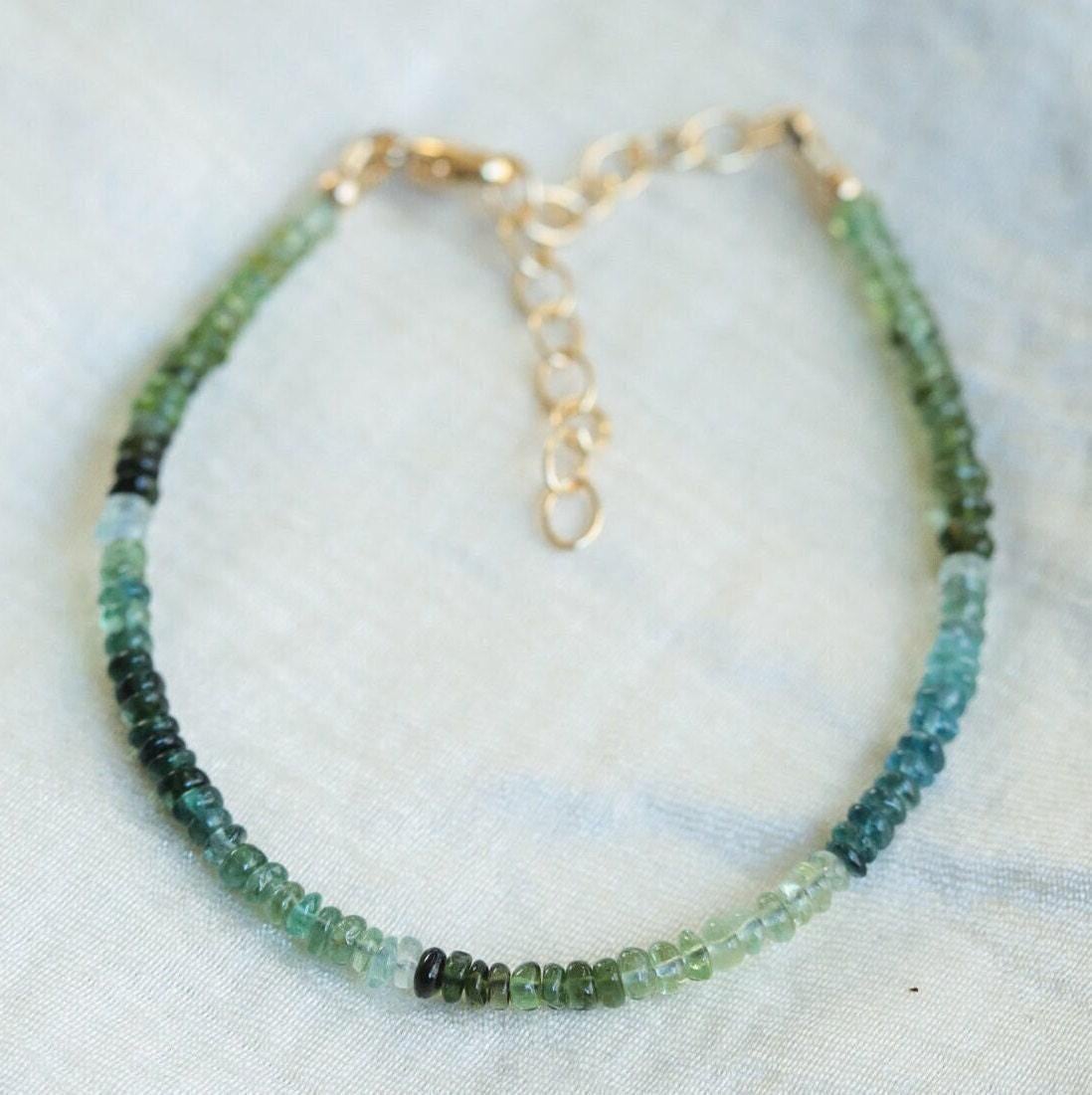 Green and blue tourmaline gemstone from Earthly Abundance Jewelry, showcasing its vibrant colors and polished, faceted surface.